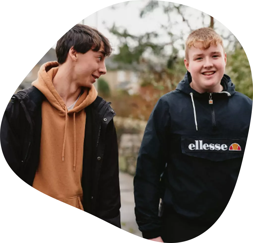 Two boys walking outside and chatting.