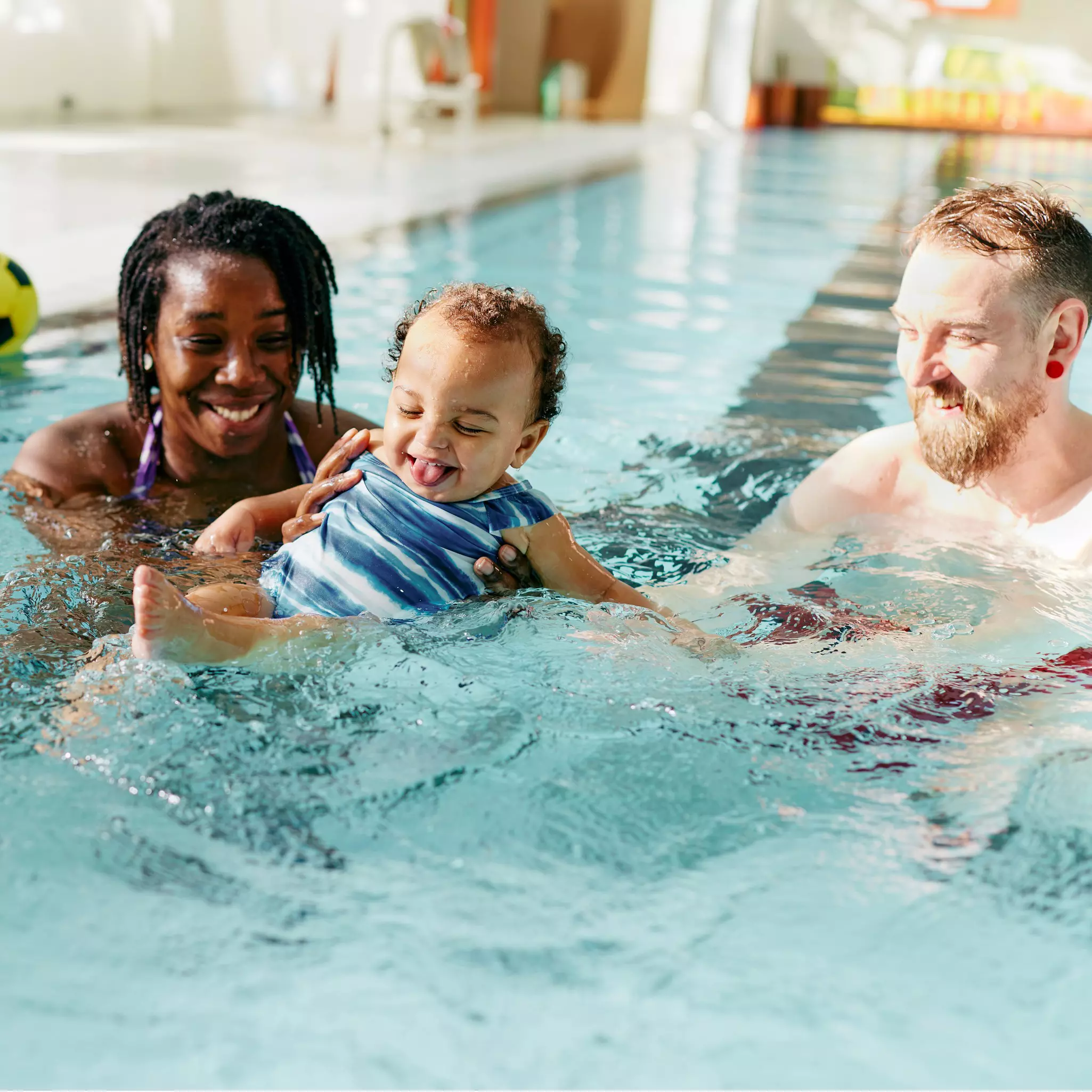 Family smiling in the pool.