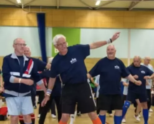 Group of older adults taking part in an indoor group exercise session.