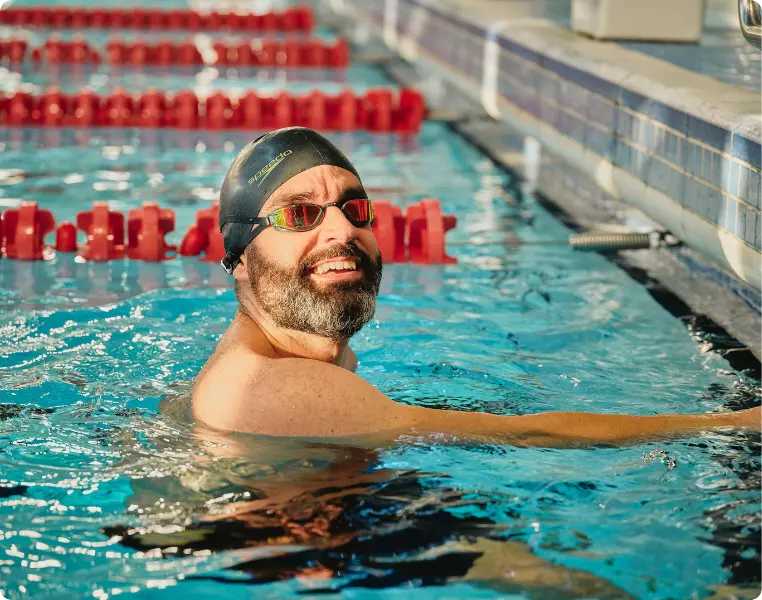 Man smiling in a swimming pool during a leisure session.