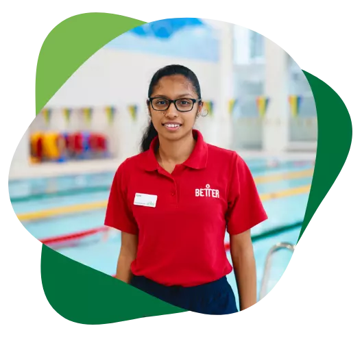 A swim instructor in a red “Better” polo stands poolside.