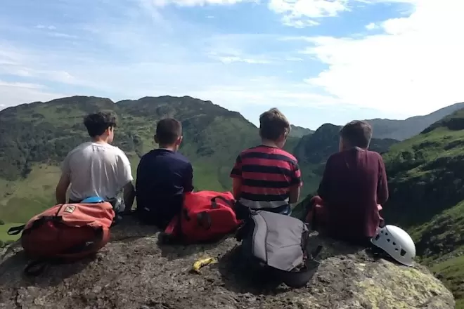 secondary school children sat on a hill