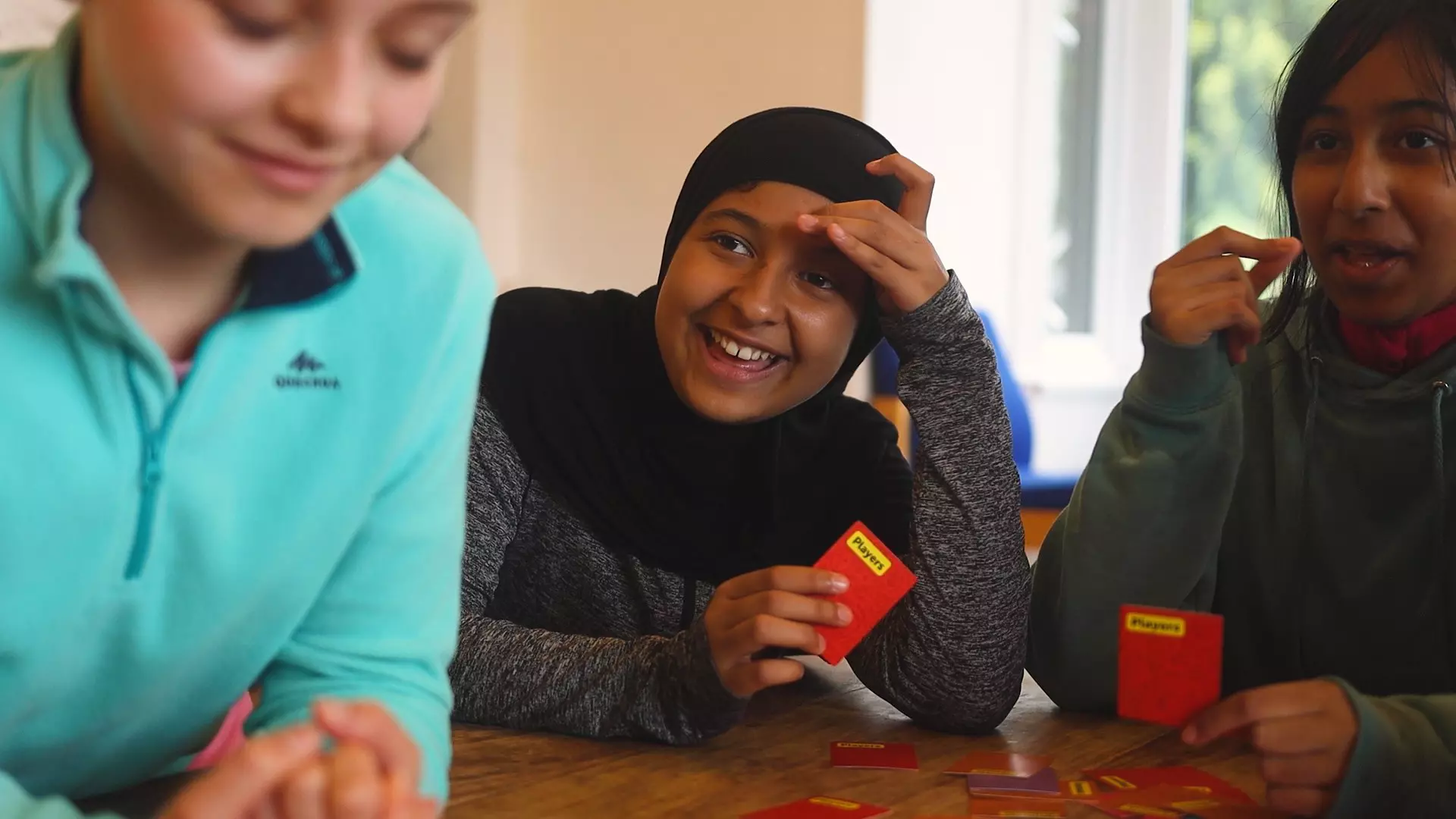 Girl playing cards and laughing