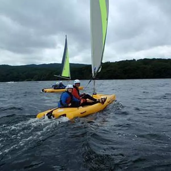 Two people in a yellow dinghy on a lake