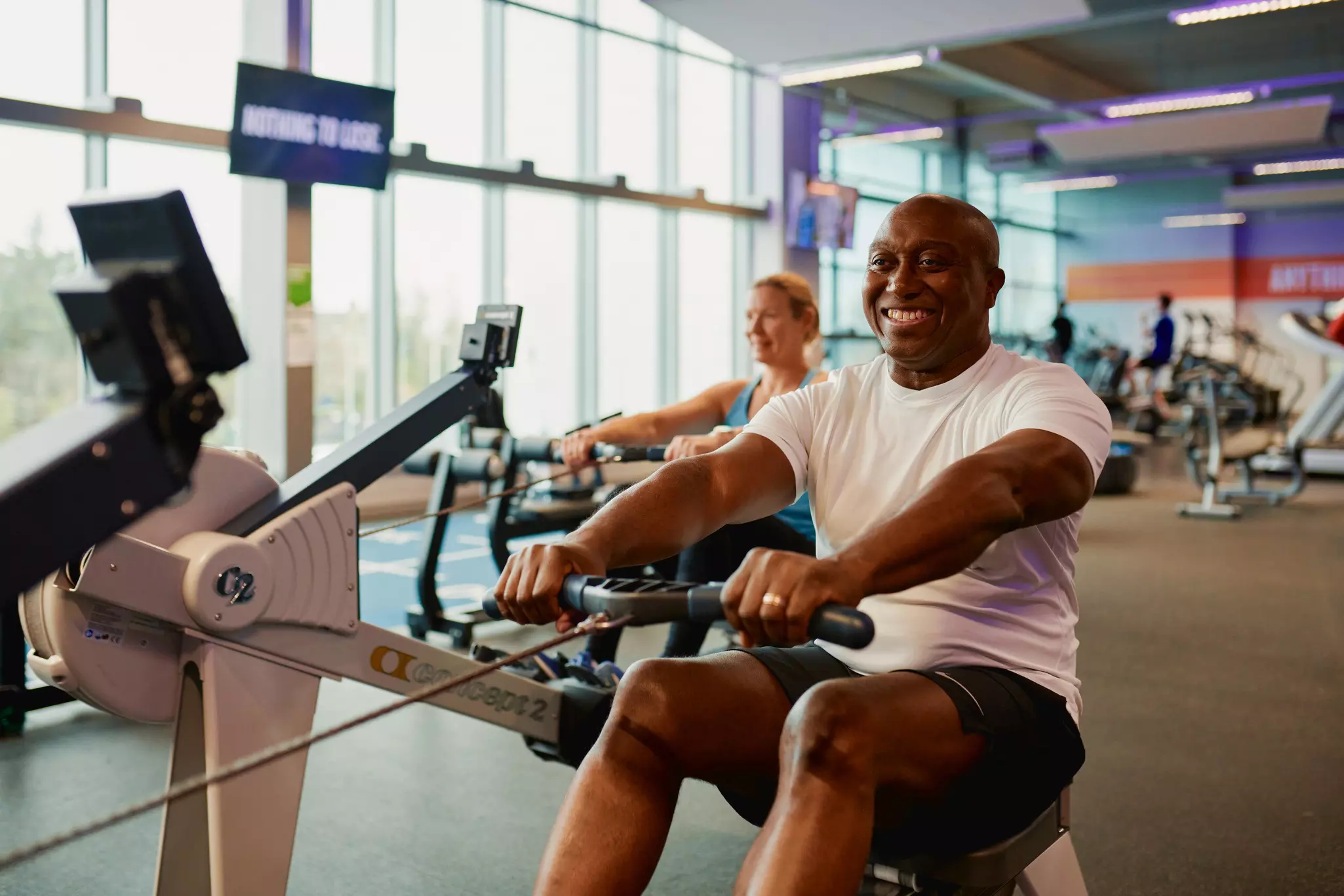 People using rowing machine in the gym.