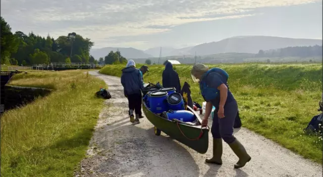 group carrying canoe