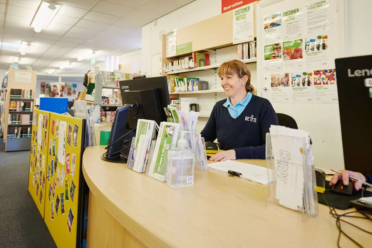 Woman in the library smiling at the reception.