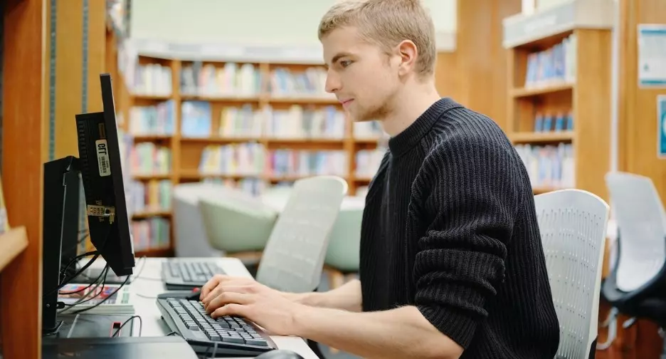 Man using a computer in a library.
