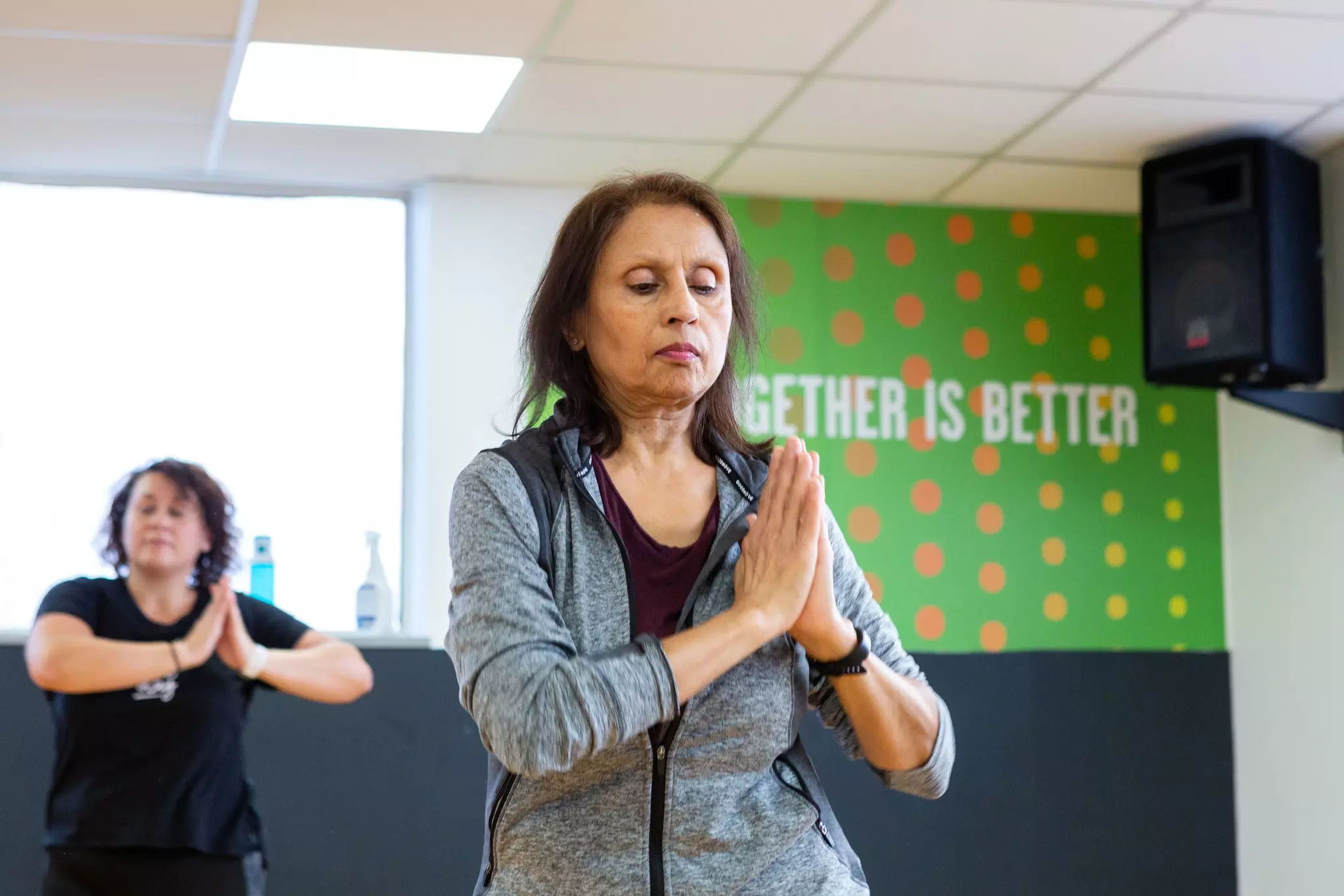 Women practicing a mindful pose in a group fitness class.