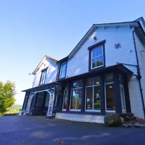 Front view of a large white house with black trim.