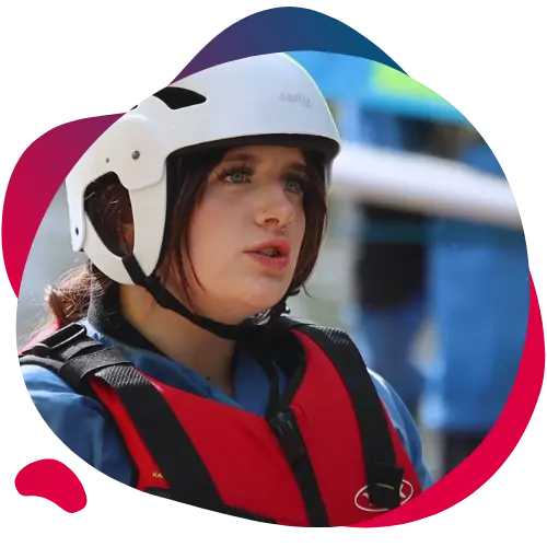 Person in a helmet and life jacket focusing during an outdoor activity.