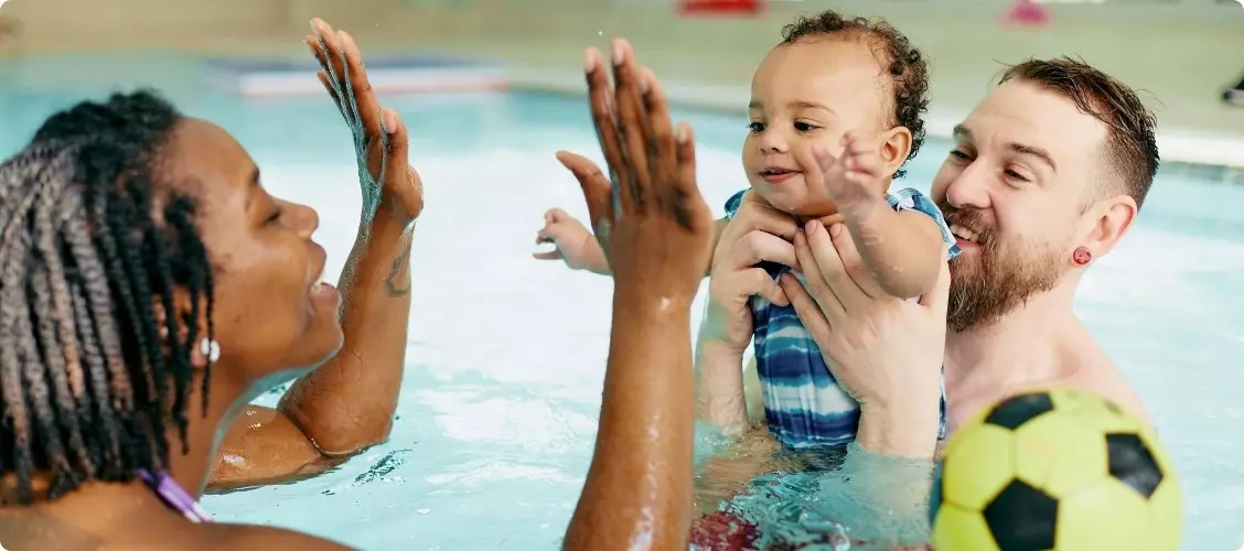 Family smiling in the pool.