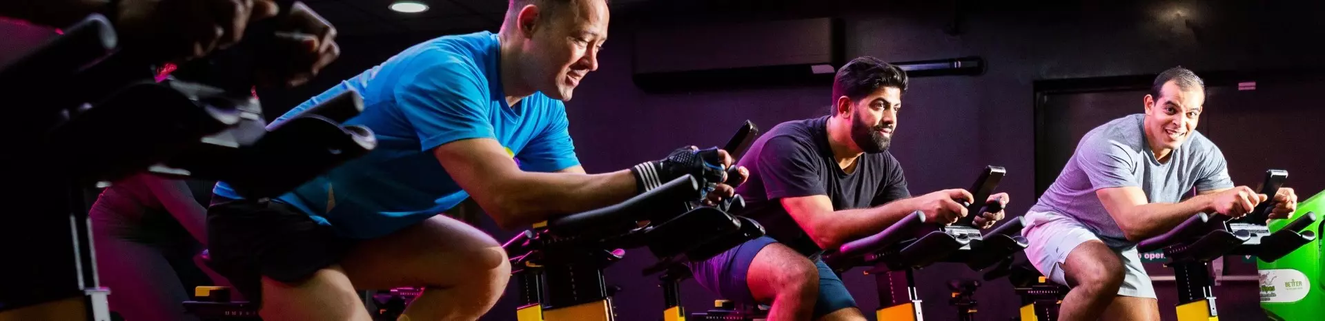 Men taking group cycling class.