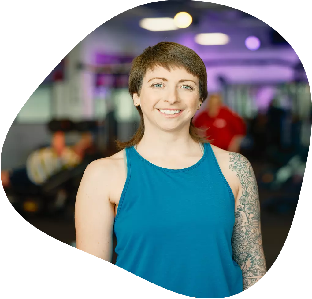 Woman standing and smiling in front of the gym. 