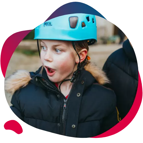Young girl in a blue helmet looking surprised or excited.