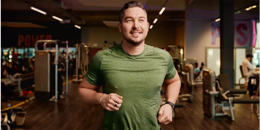 Man jogging on a treadmill in a gym.