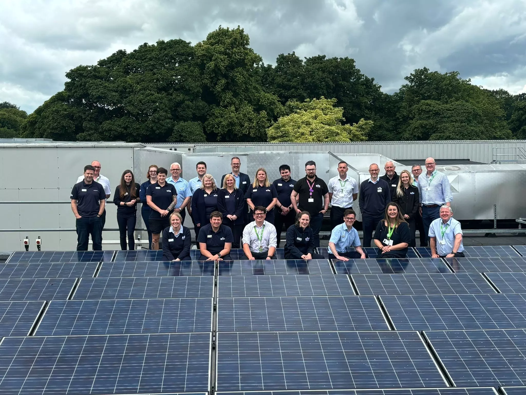 GLL staff standing by solar panels