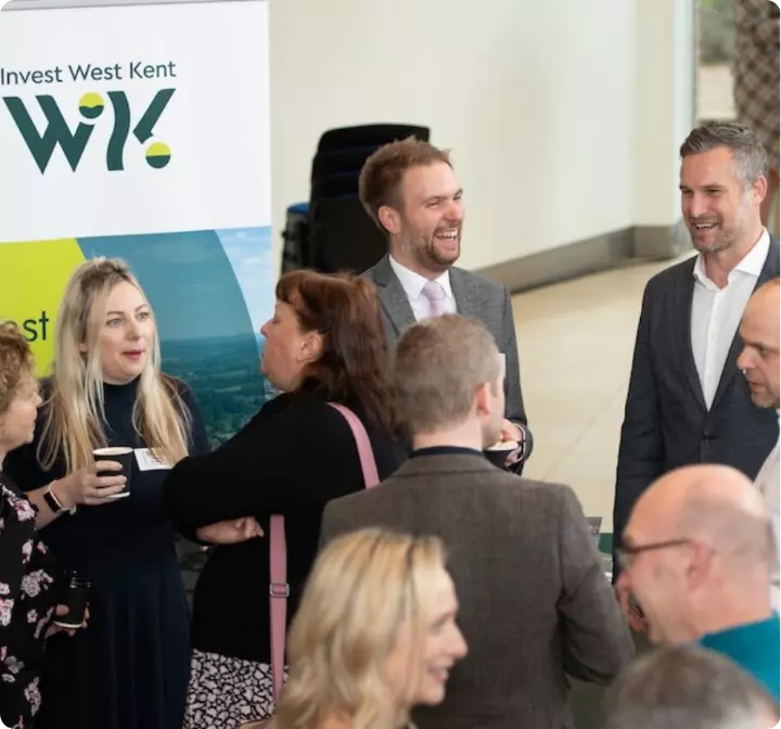 People chat and laugh at an Invest West Kent networking event.