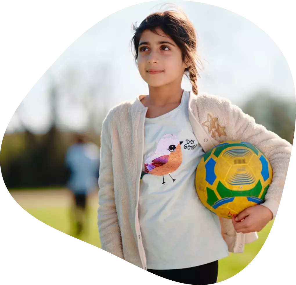 Girls standing holding a ball. 