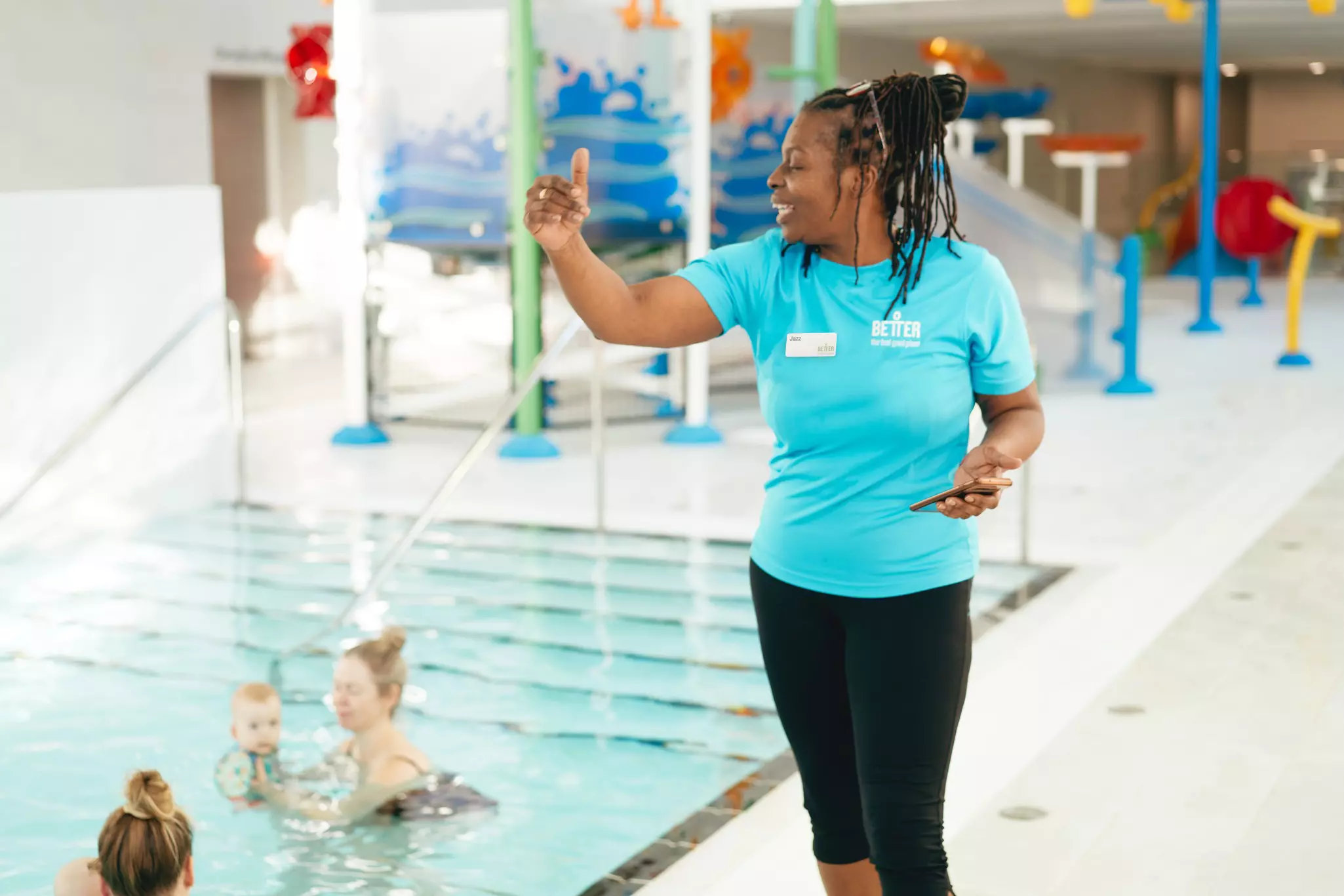 Swimming instructor giving guidance to children in an indoor pool.