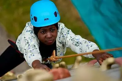 Girl with a blue helmet on a climbing wall