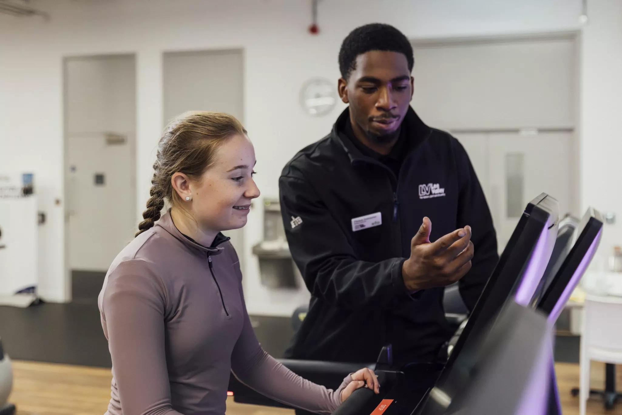 Better employee showing teenager how to use a machine