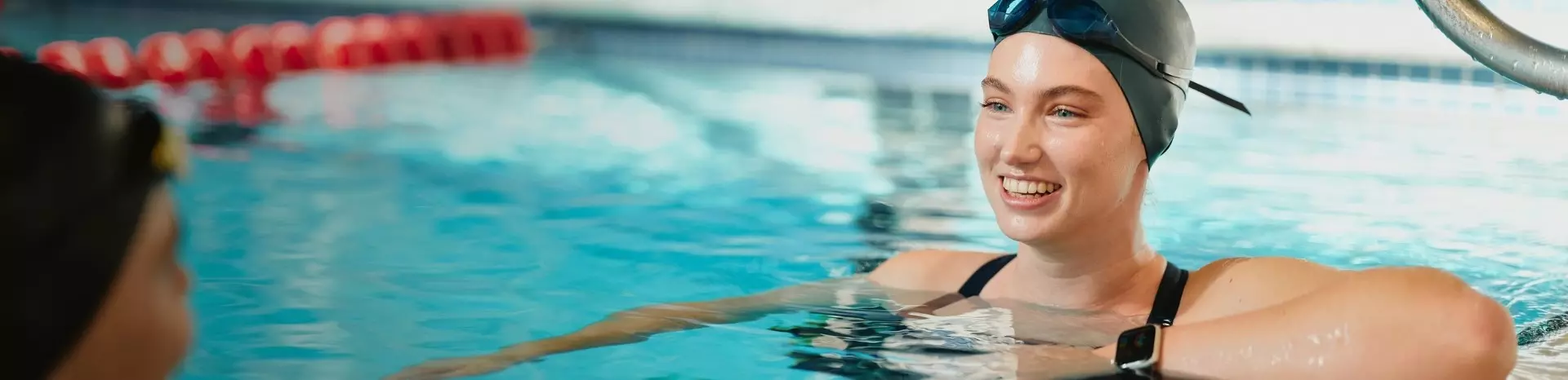 Women chatting and smiling in the pool.