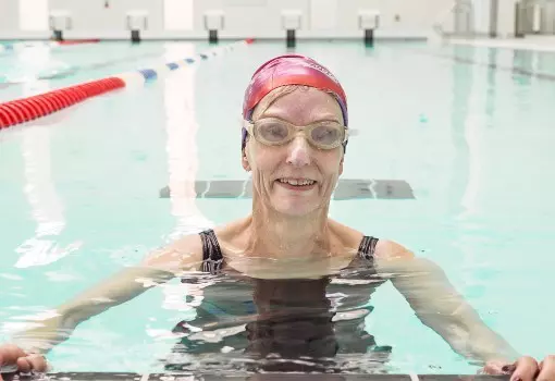 Woman in swim cap and goggles in a pool.
